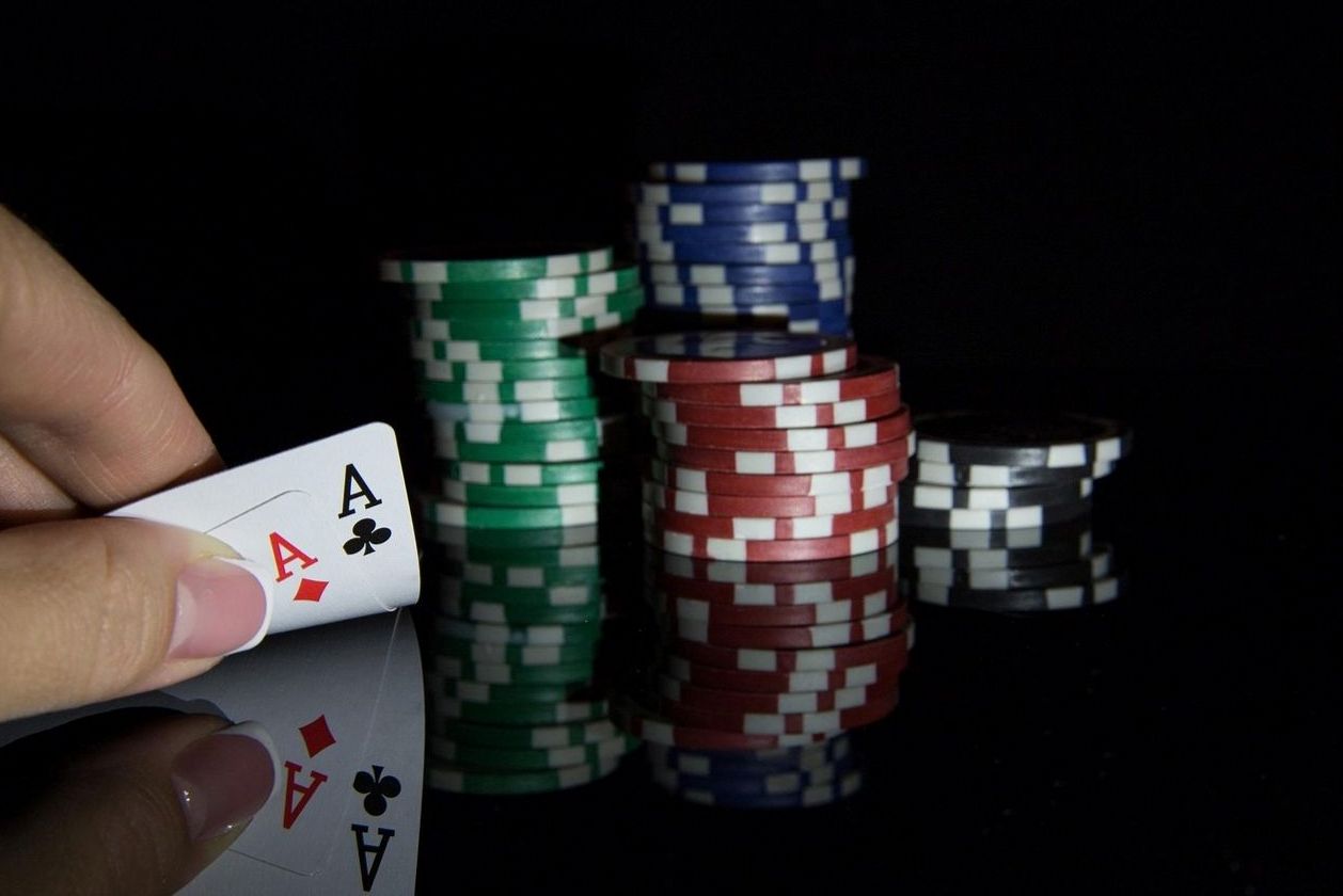 Pokerhost erklärt Gästen am Tisch aufmerksam die nächste Spielrunde